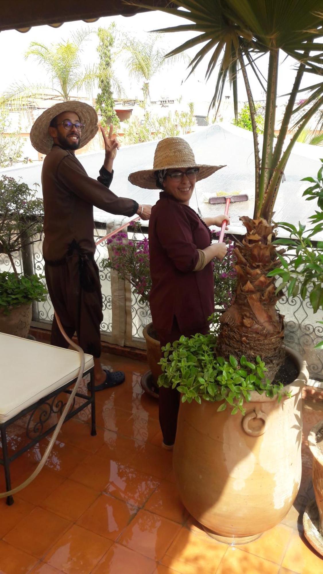 Riad Les Nuits De Marrakech มาร์ราเกช ภายนอก รูปภาพ A woman watering a plant